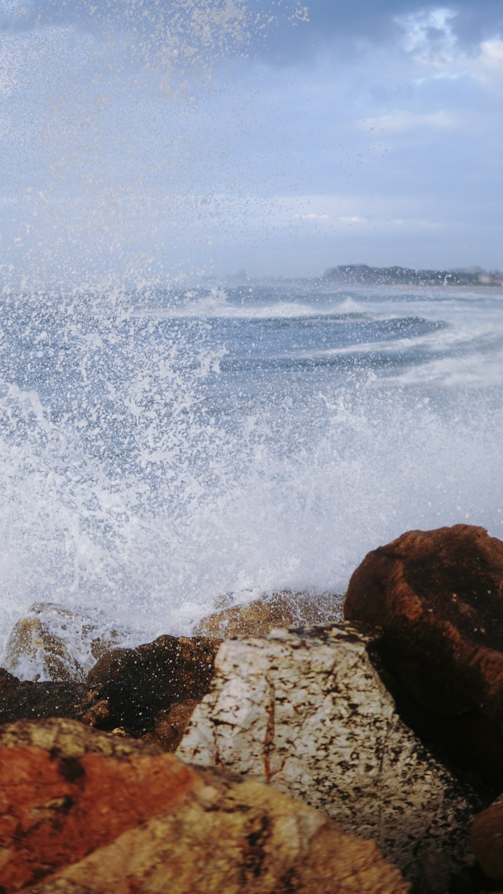 ocean waves crashing on brown rock