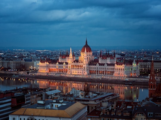 brown and white concrete building during night time in Hungarian Parliament Building Hungary