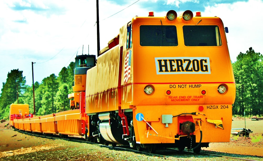 yellow and brown train on rail tracks during daytime