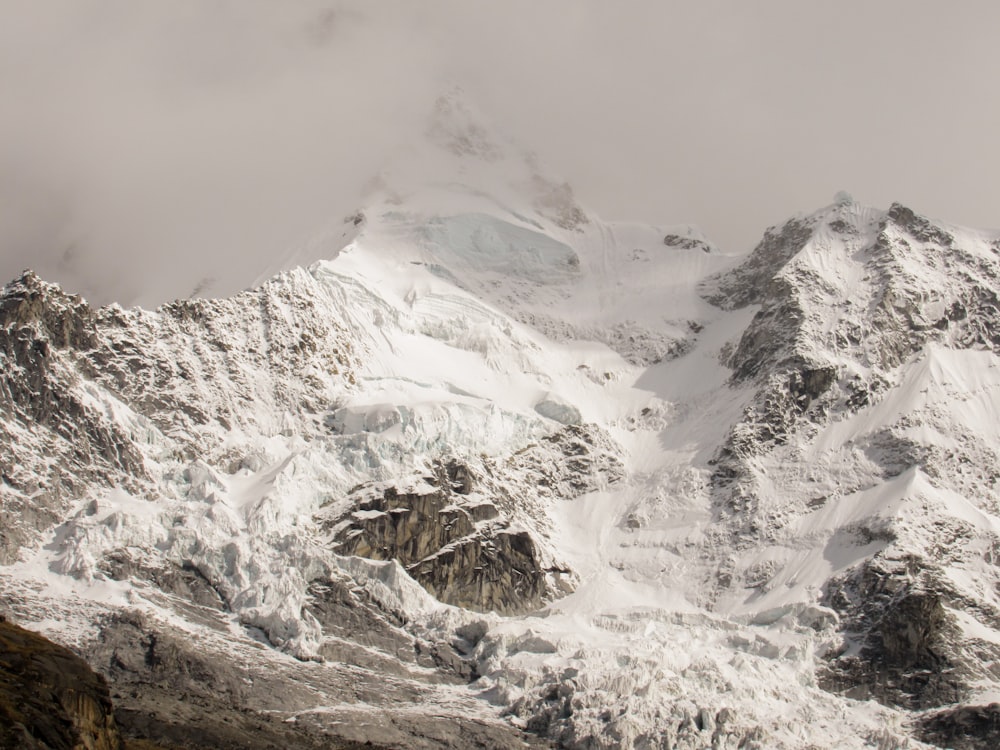 snow covered mountain under cloudy sky during daytime