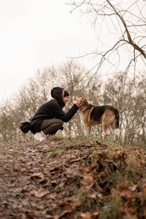 A proud veteran owner gently holding a German Shepherd, symbolizing dedication and care.