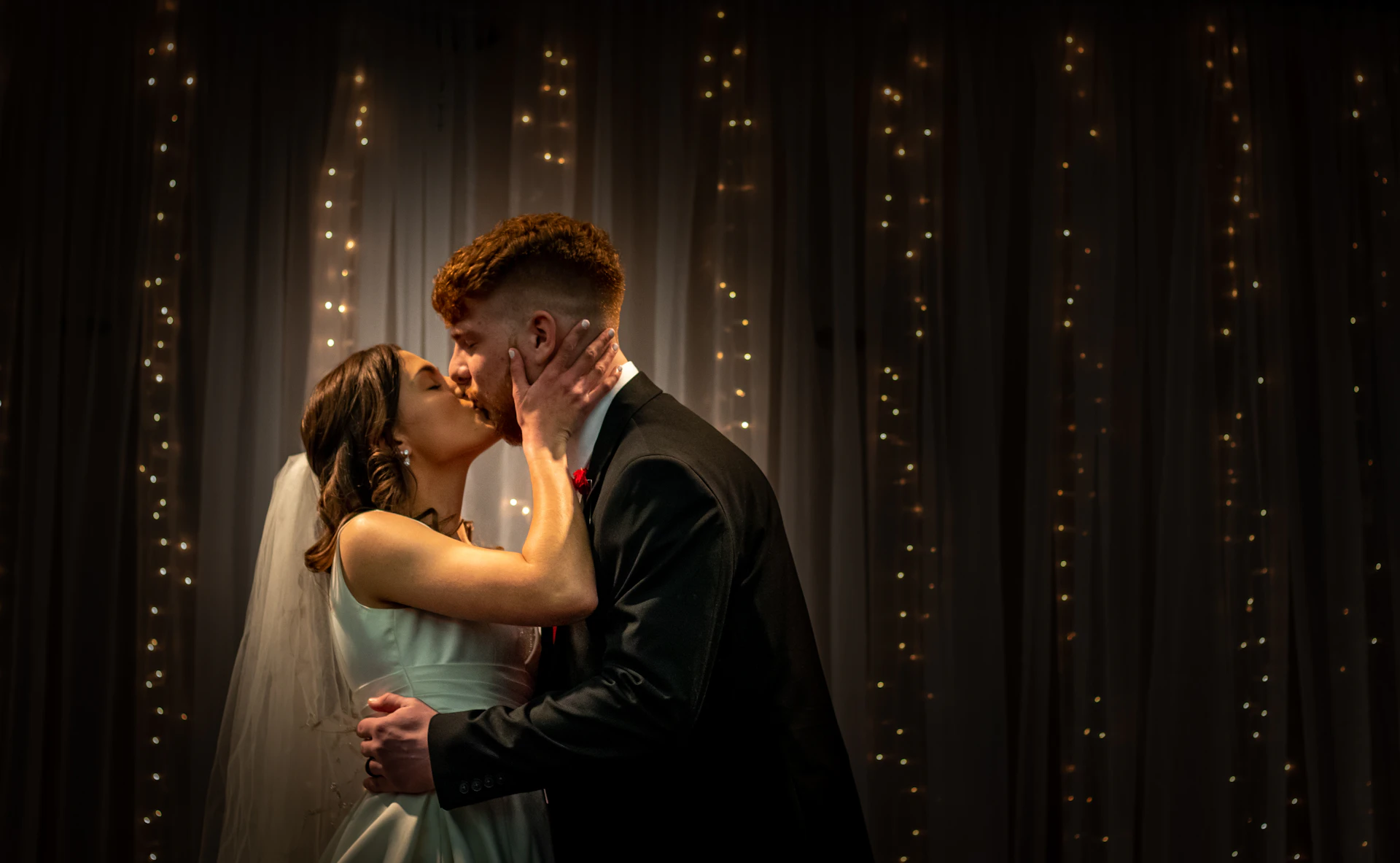 Wedding couple embracing under warm bokeh lights