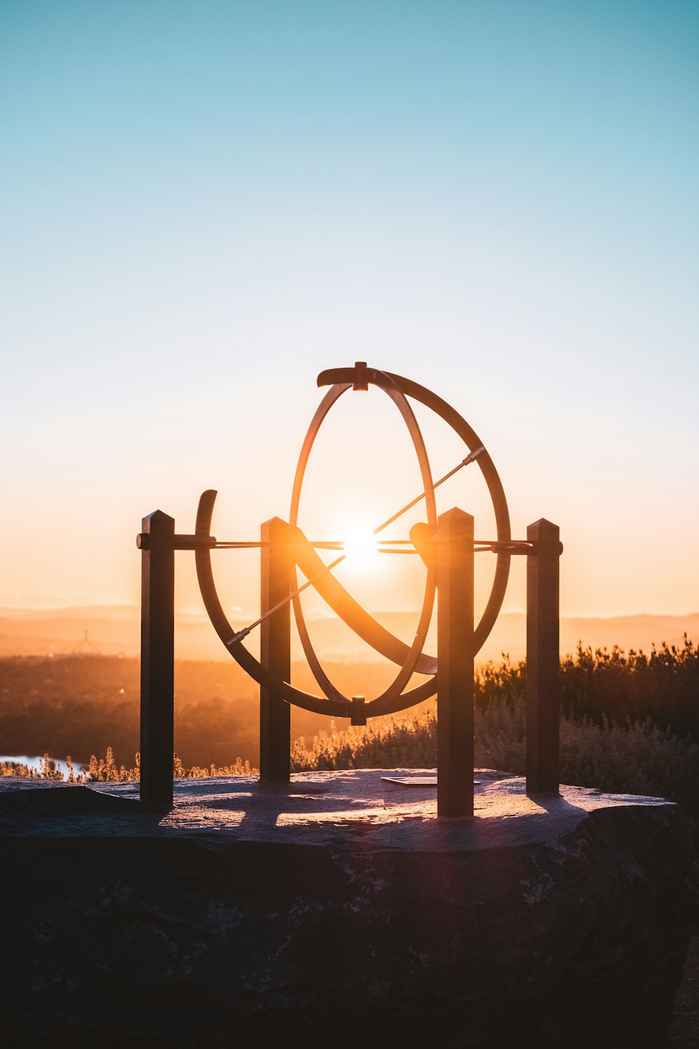 Arco de metal marrón en suelo cubierto de nieve durante la puesta del sol