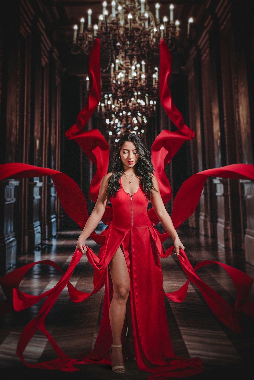 woman in red dress standing beside red curtain