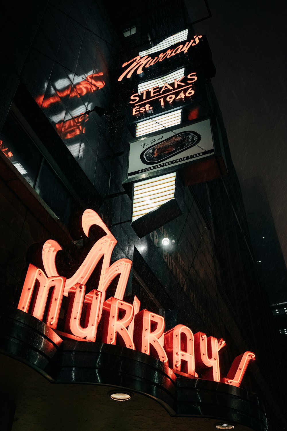 a neon sign for a restaurant on the side of a building