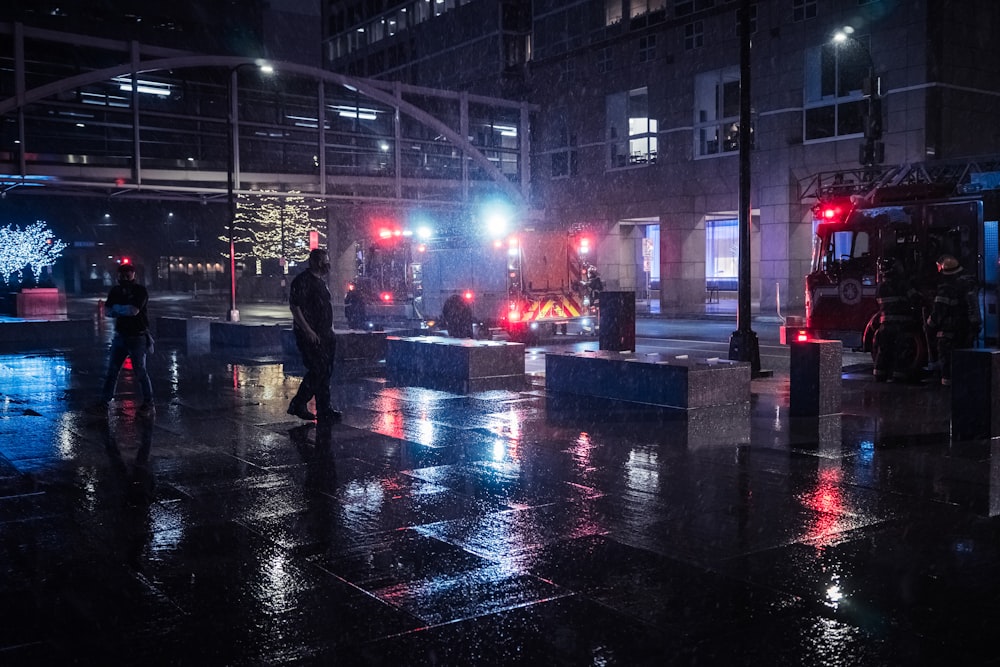 homme en veste noire marchant dans la rue pendant la nuit