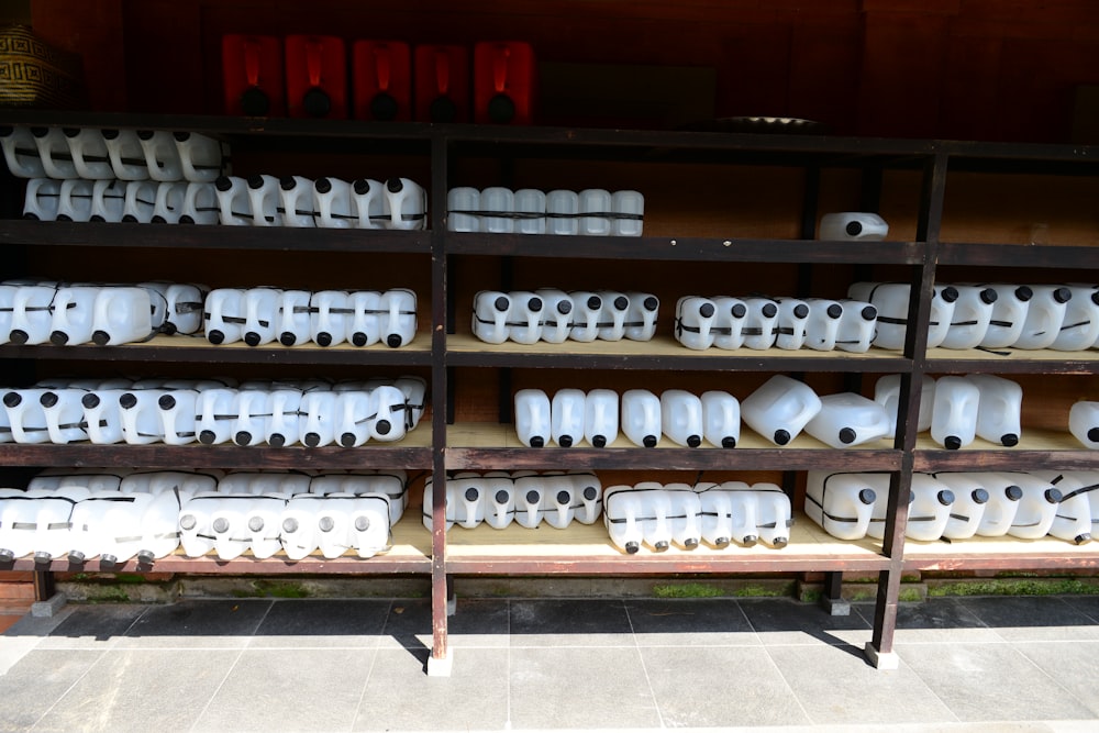 white ceramic mugs on black wooden shelf