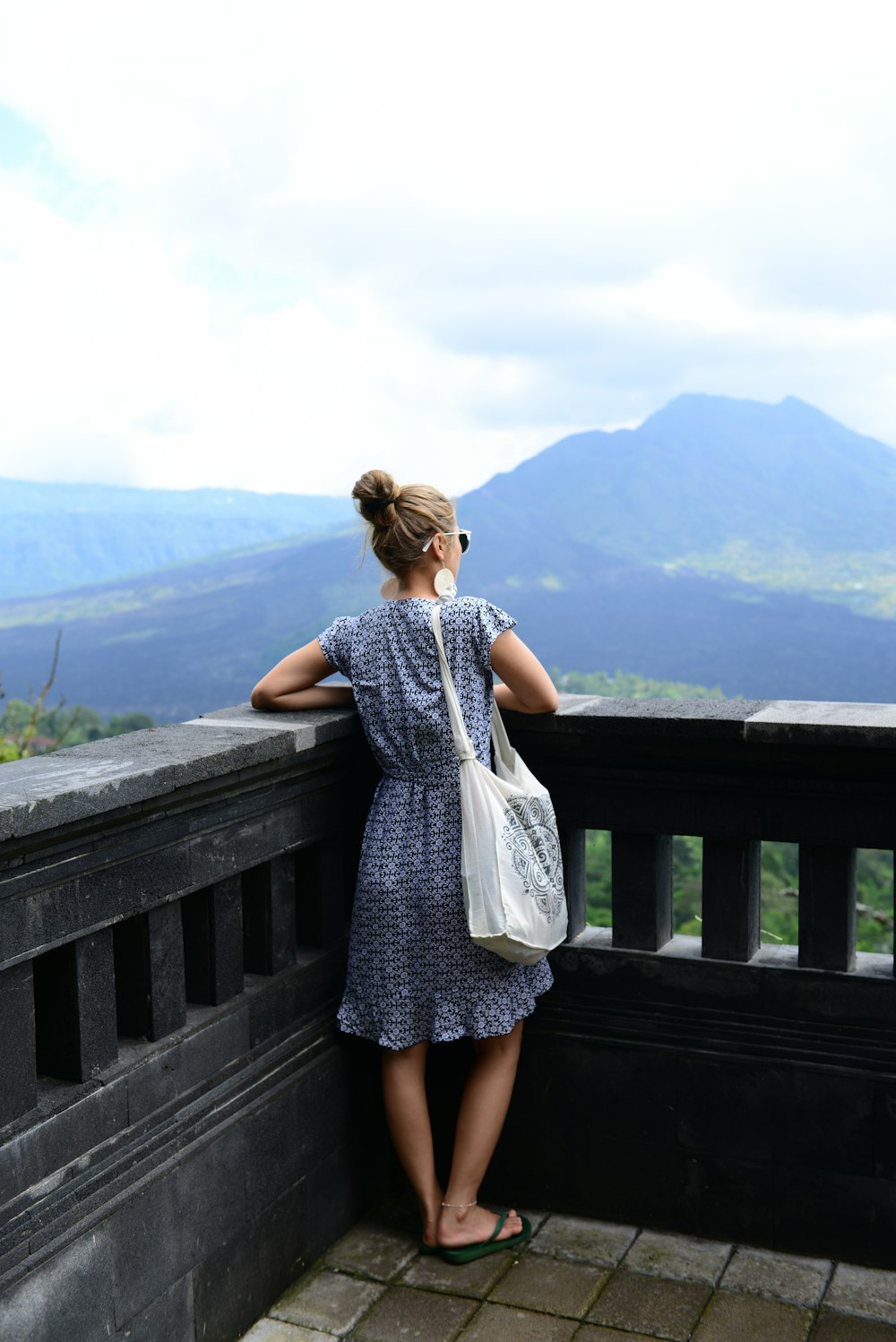 woman in white and black dress standing on wooden bridge during daytime