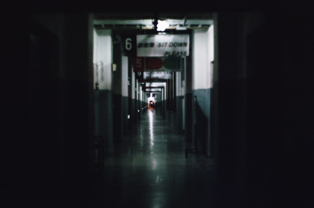 man in black jacket walking on hallway