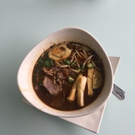 A steaming bowl of Vietnamese noodle soup with vibrant toppings.