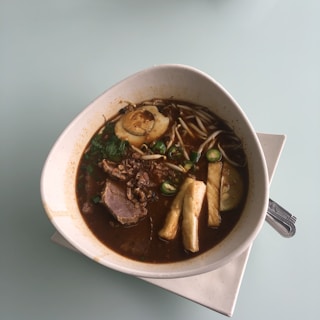 A steaming bowl of Vietnamese noodle soup with vibrant toppings.
