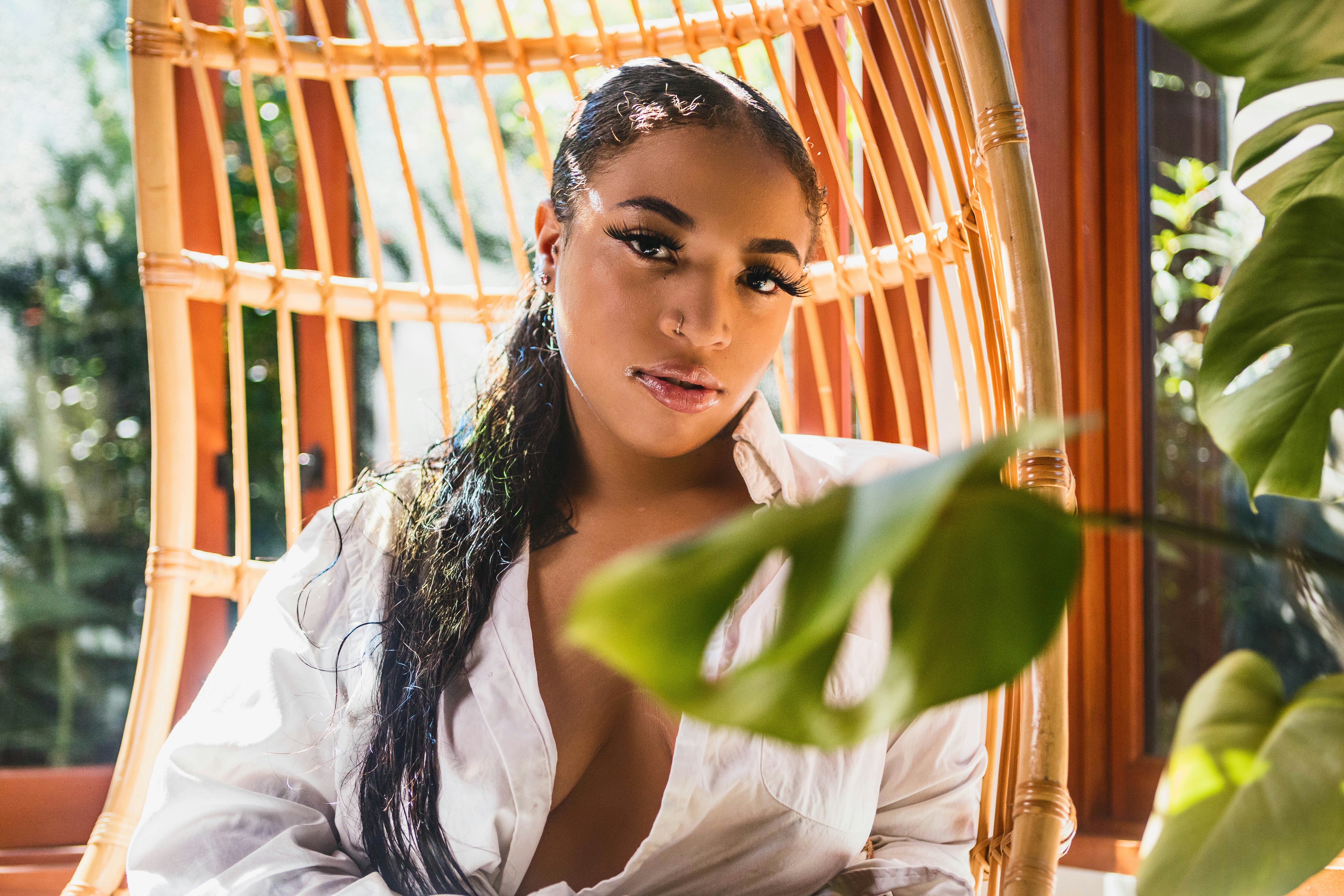 woman in white long sleeve shirt holding green leaf
