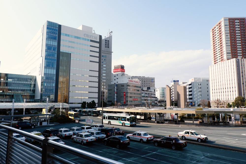 cars parked on parking lot near high rise buildings during daytime