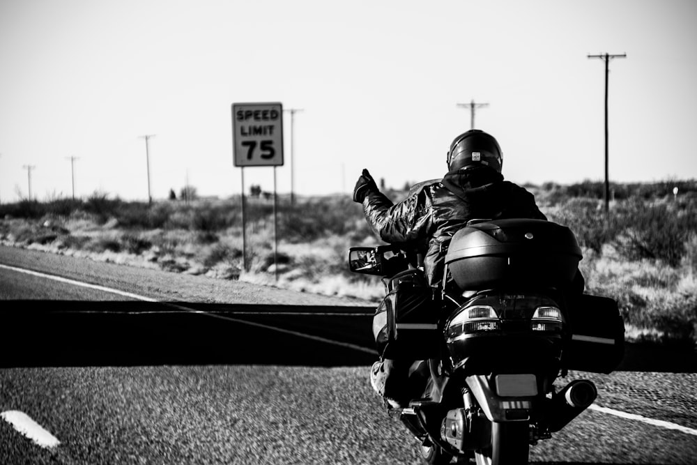 grayscale photo of man riding motorcycle