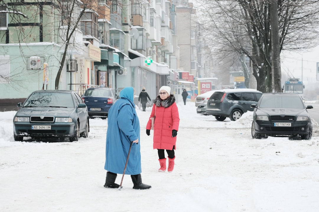 woman in blue coat standing on snow covered ground during daytime