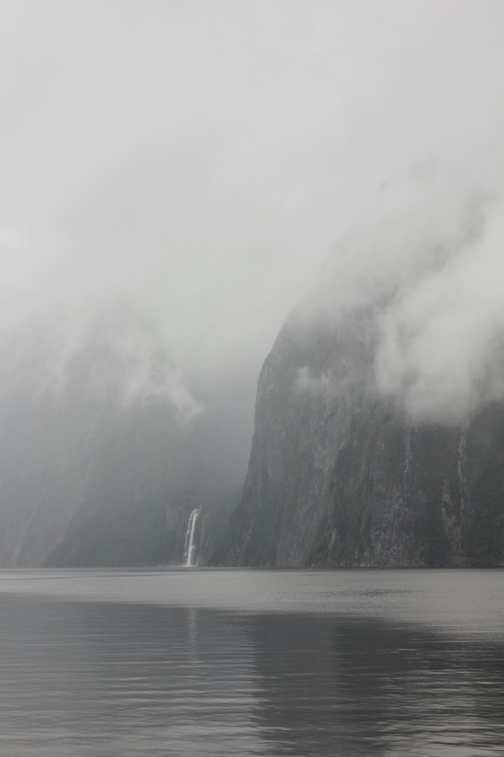 person standing on rock formation near body of water during daytime