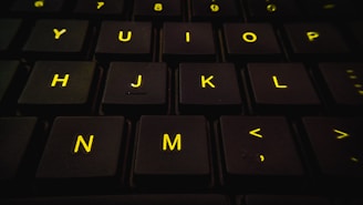 Close-up of hands typing on a keyboard with a vibrant yellow and black color scheme.