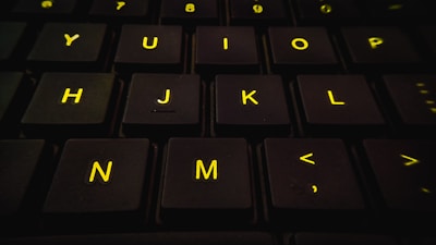 Close-up of hands typing on a keyboard with a vibrant yellow and black color scheme.