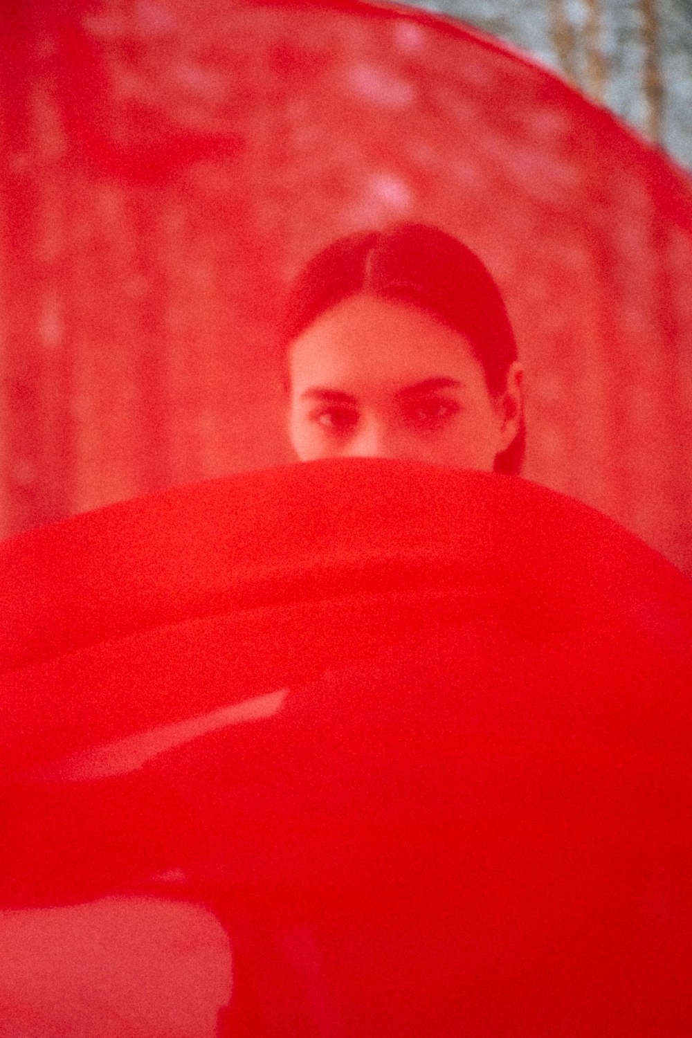 man in red shirt standing near red curtain