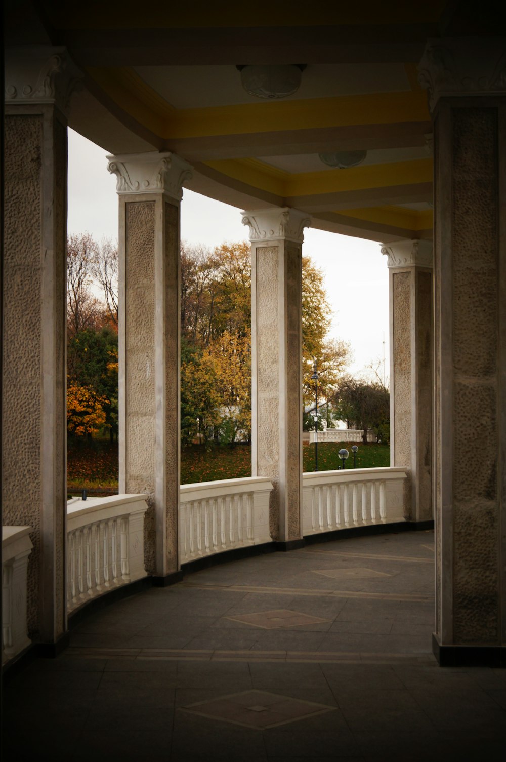 white concrete pillar near green trees during daytime