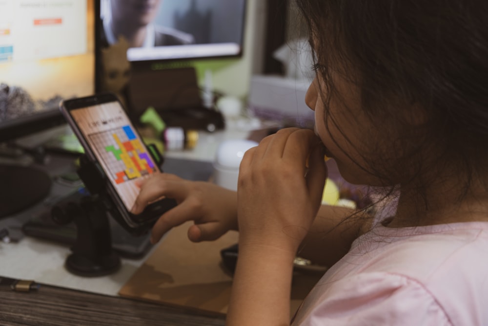 Frau im rosa Hemd hält Smartphone