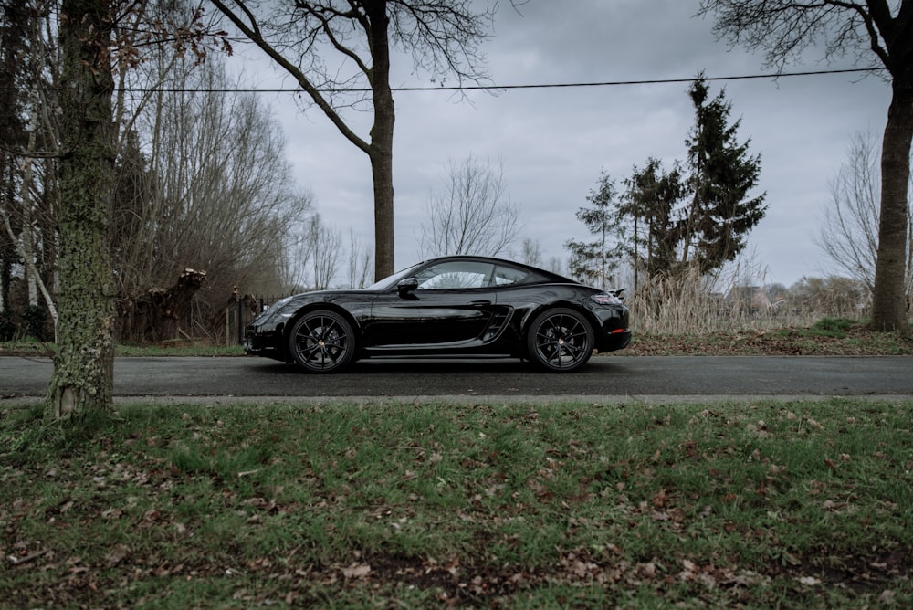 black coupe parked on gray concrete road