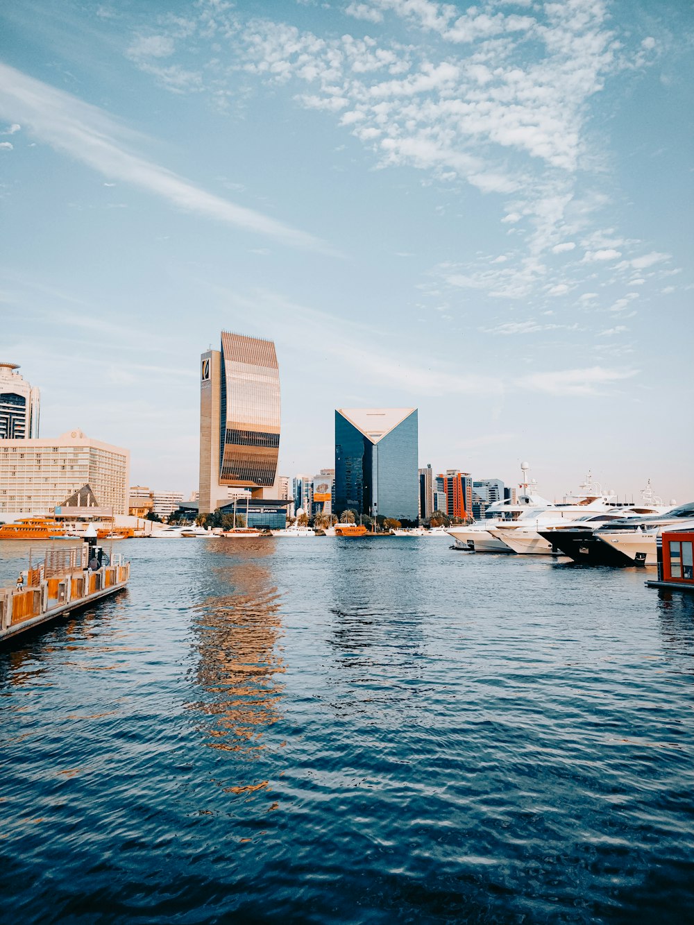 white and brown boat on water near city buildings during daytime