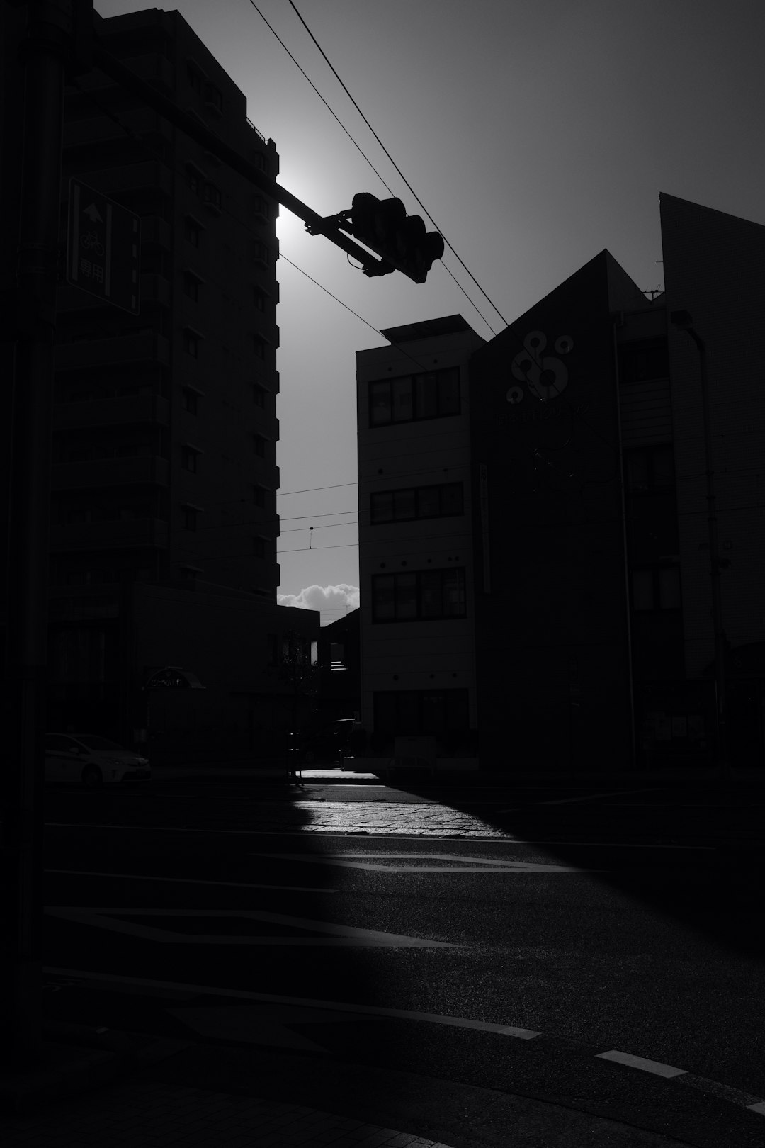 grayscale photo of street light near high rise building