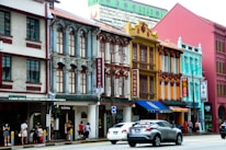A vibrant street scene in Singapore with colorful shophouses and bustling markets.