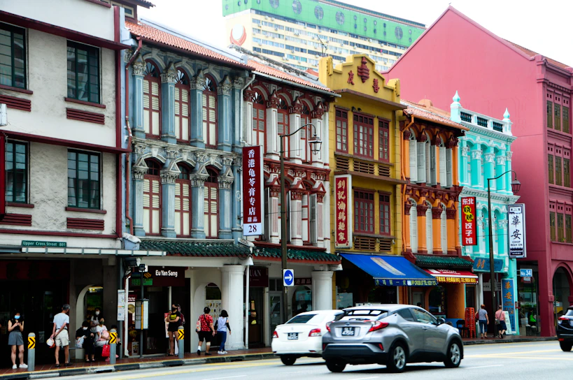 A vibrant street scene in Singapore showcasing colorful shophouses and bustling local life.