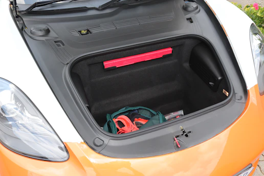 A neatly organized car trunk with labeled bins and sports gear arranged for a busy family day.