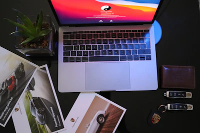 Close-up of hands reviewing car listings and budget notes on a sleek desk.