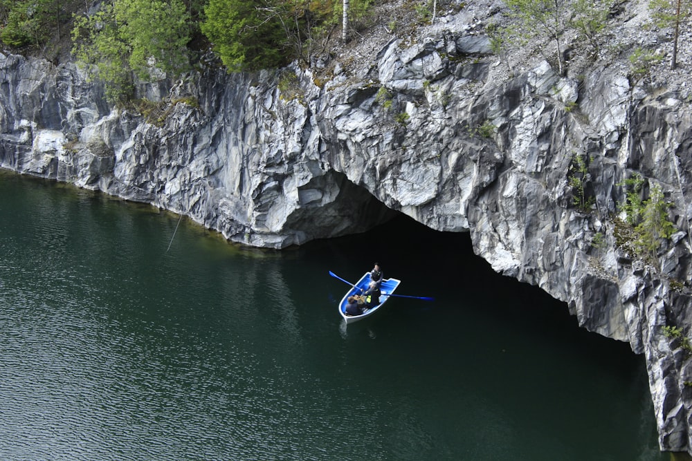 Homme en kayak bleu sur la rivière près de Gray Rocky Mountain pendant la journée