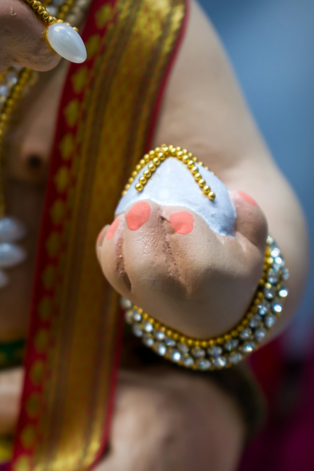 person wearing gold and white beaded bracelet