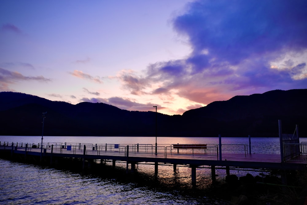 silhouette of mountain near body of water during sunset