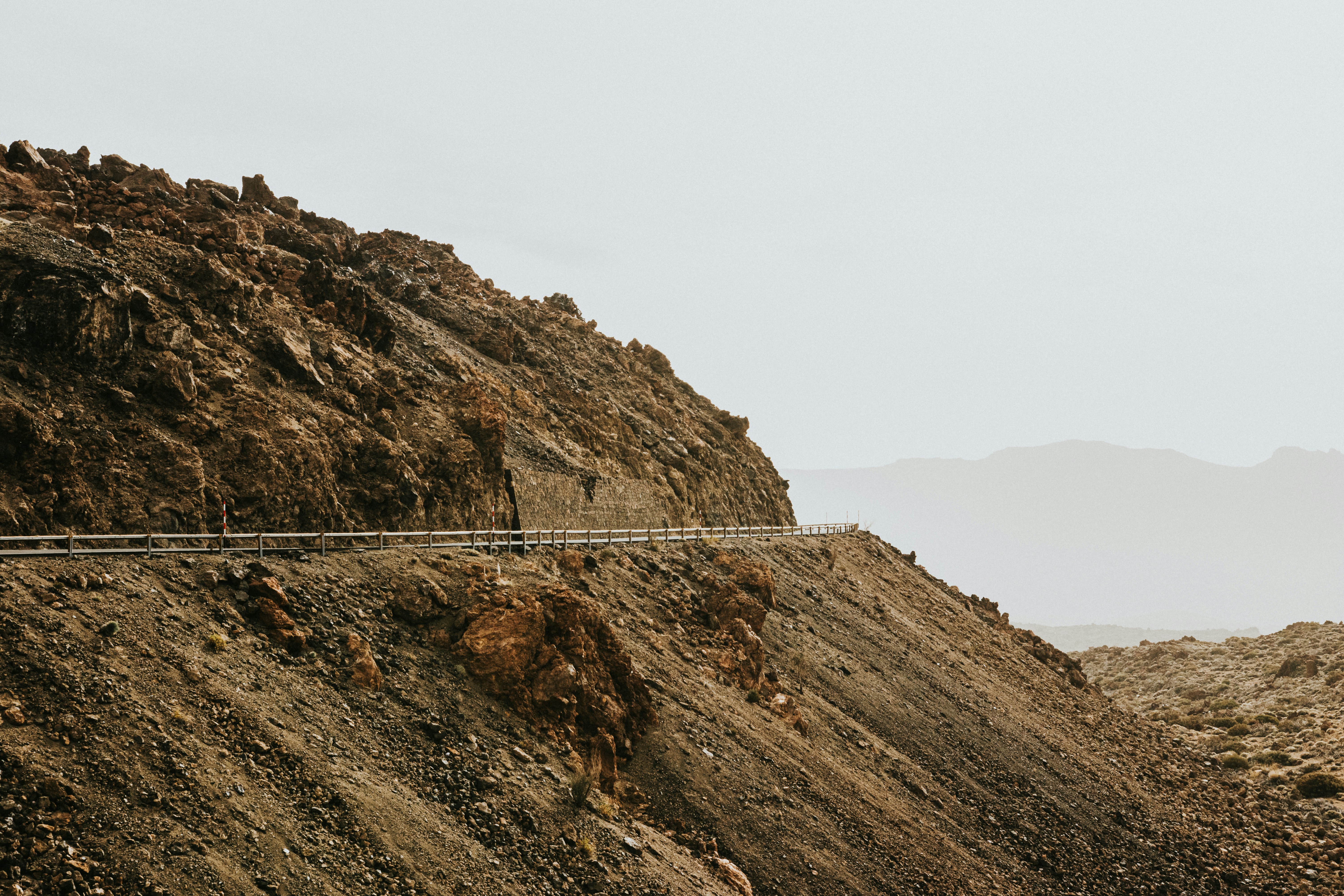 Brauner Berg tagsüber unter weißem Himmel