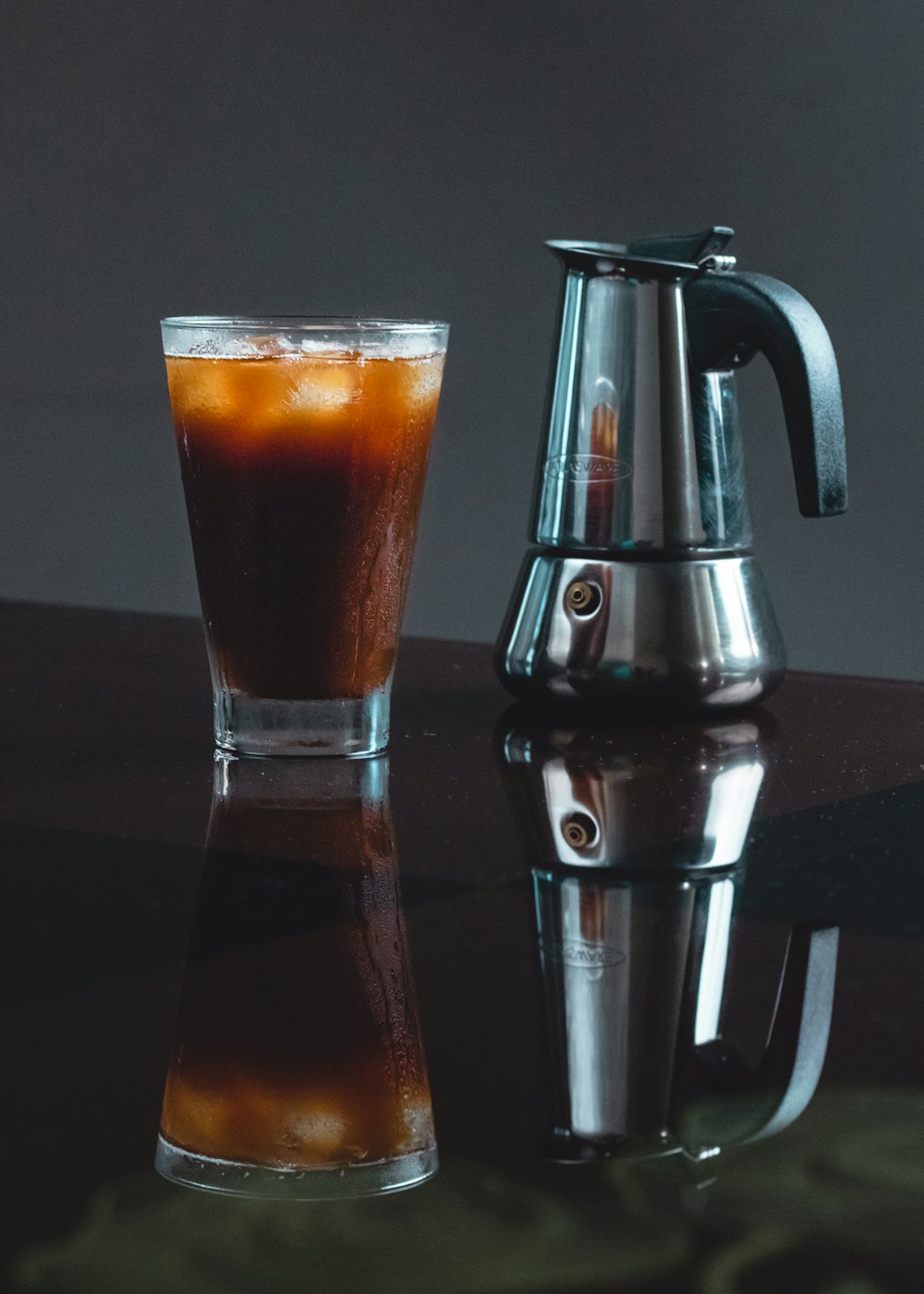 verre à boire transparent avec un liquide brun à l’intérieur