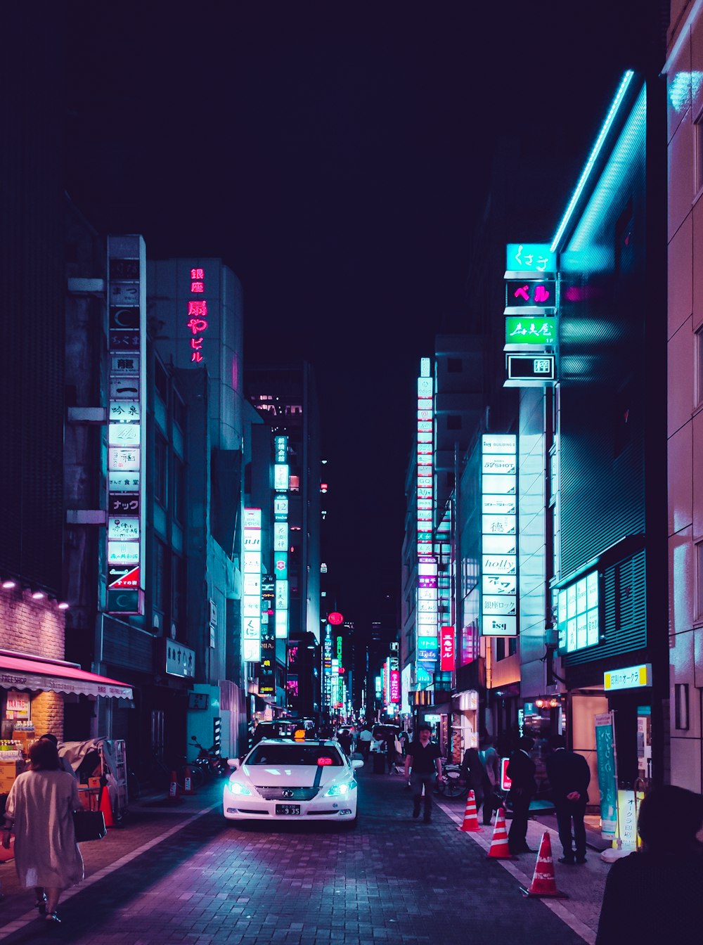persone che camminano per strada durante la notte