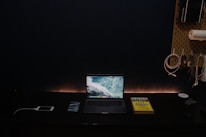 A minimalist desk setup with a laptop, fitness gear, and a deep blue ambient light.