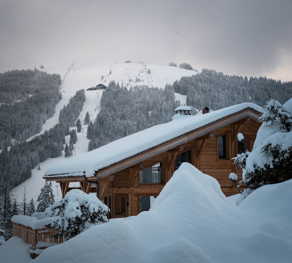 casa de madeira marrom na montanha coberta de neve durante o dia