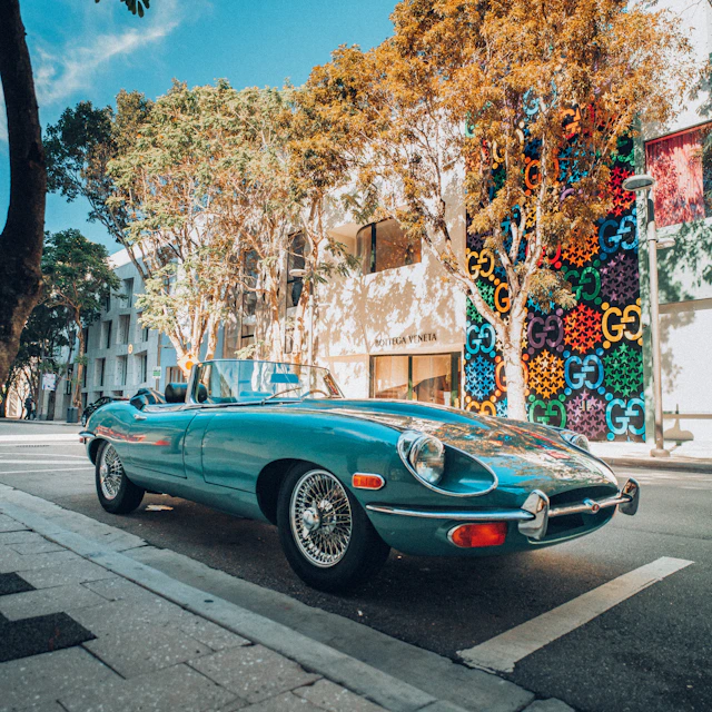blue coupe parked on sidewalk during daytime