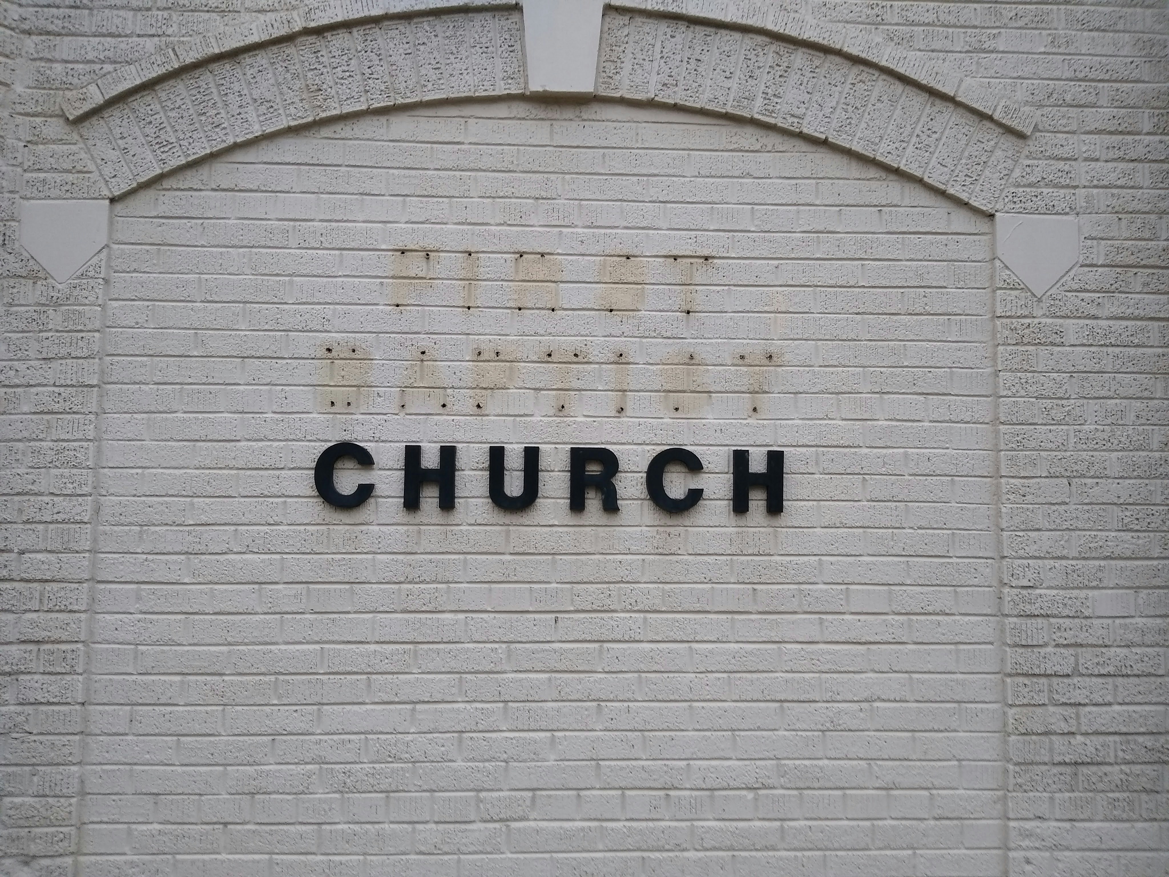 a brick wall with a sign that says, the church