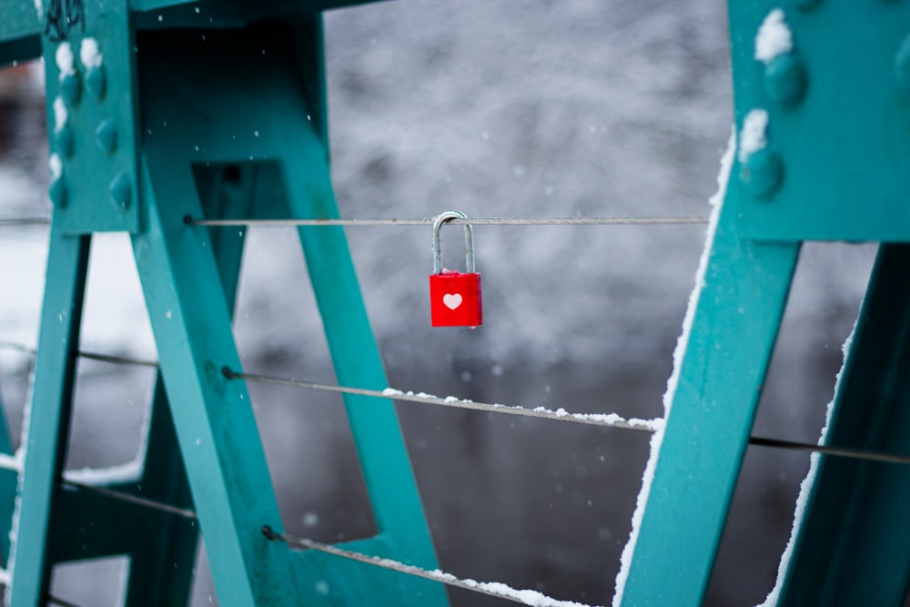 red padlock on blue metal fence