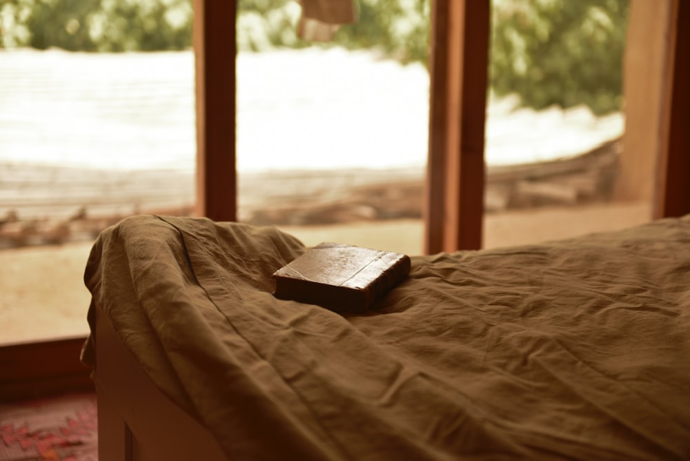 black book on brown bed linen