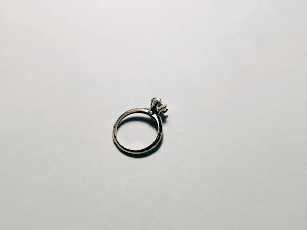 Close-up of a minimalist 925 silver ring with a subtle shine on a soft fabric background.