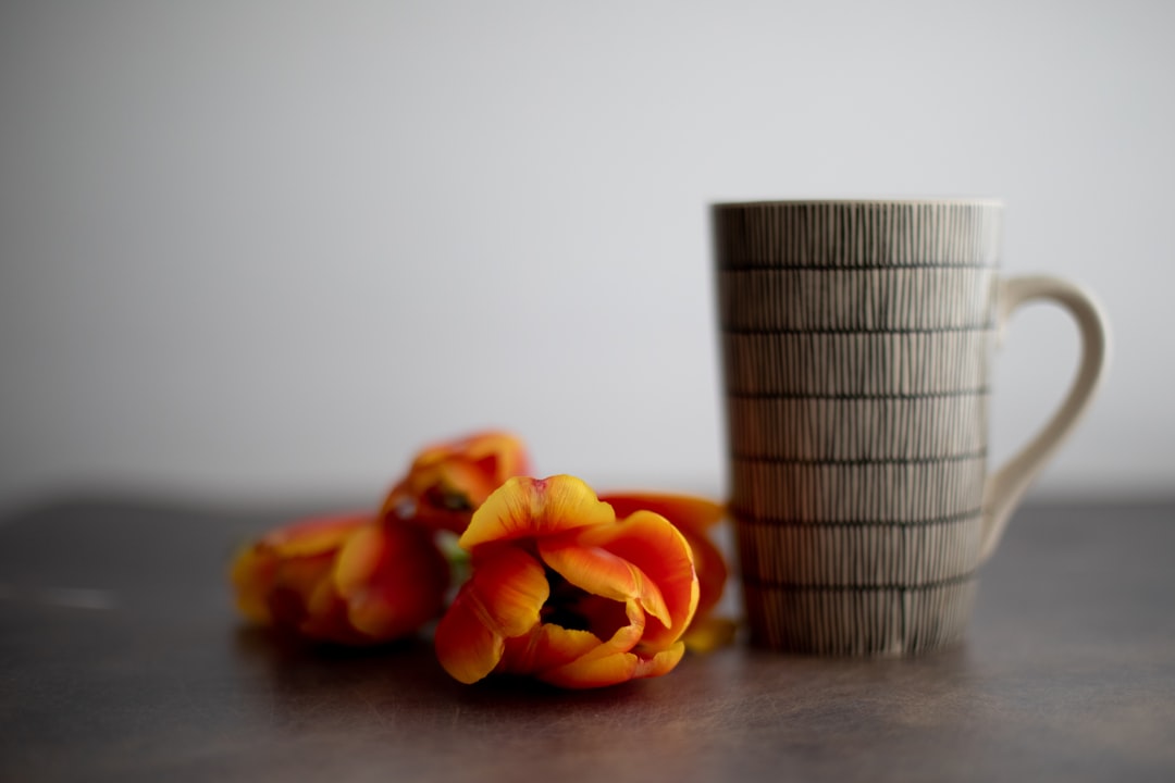 orange tulips in gray ceramic mug