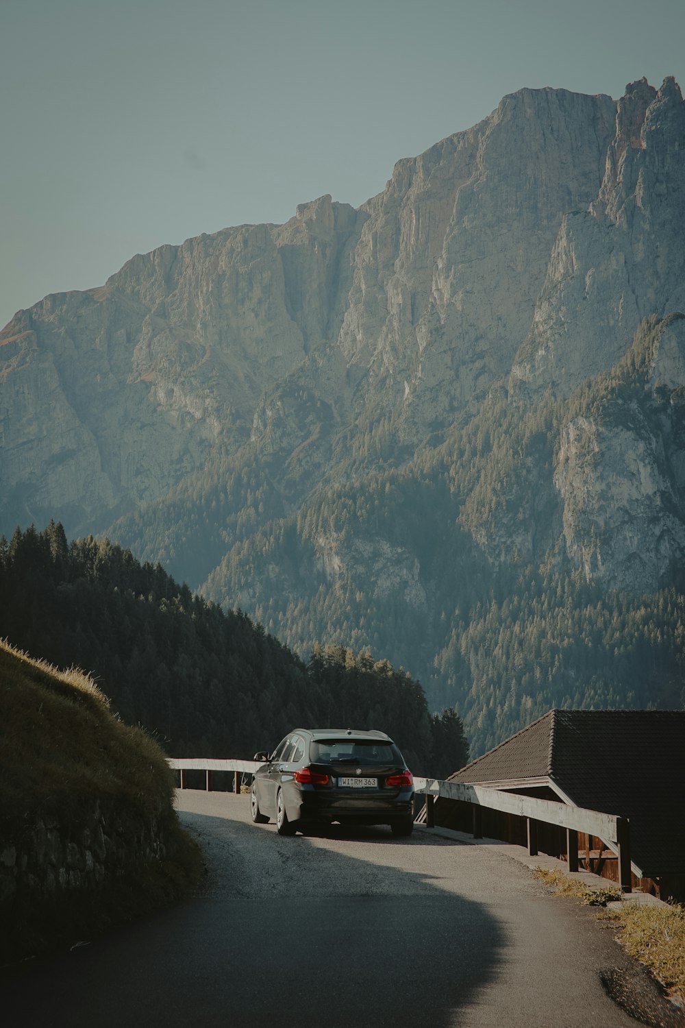 Weißer Van tagsüber in der Nähe von Brown House und Mountain geparkt