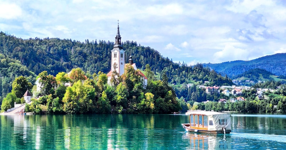 white and brown concrete building near green trees and body of water during daytime