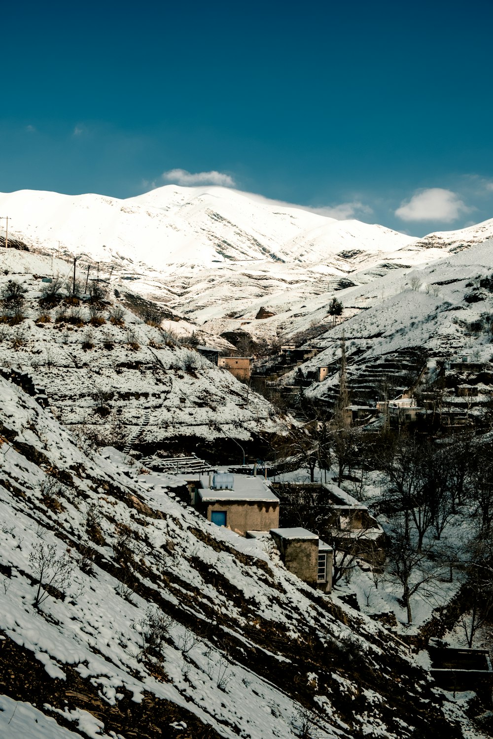 white and brown house on snow covered mountain during daytime