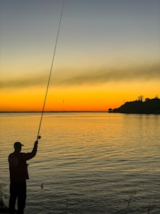 Fisherman casting a line into the calm waters of Rio Parada at sunset
